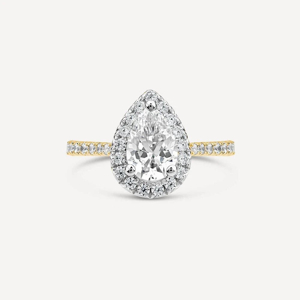Pear-shaped diamond ring with a halo setting, set on a yellow gold band accented with pavé diamonds.